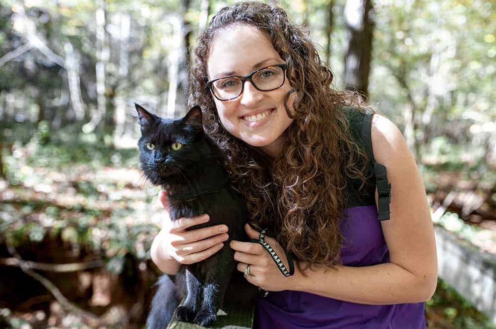 Woman with a black cat on a hike