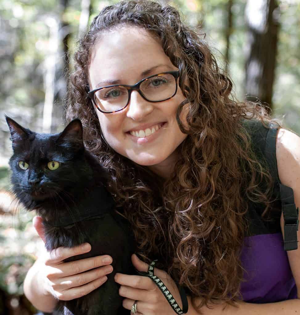 woman with black cat on a harness