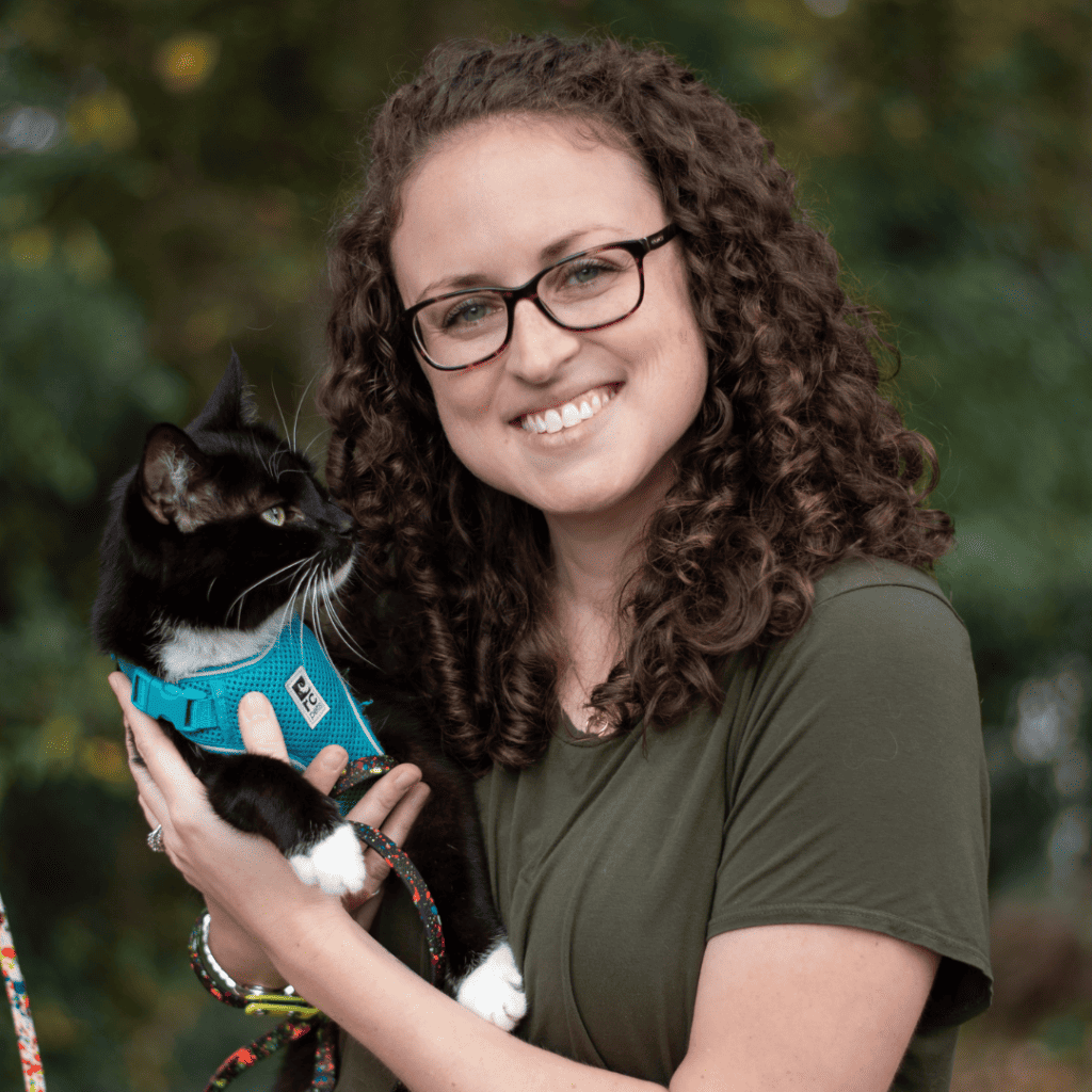 woman holding cat in arms outdoors