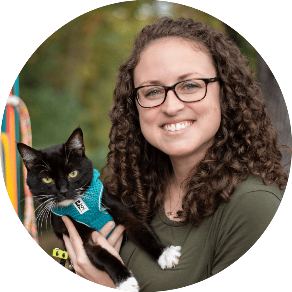 woman holding cat outside and looking at camera